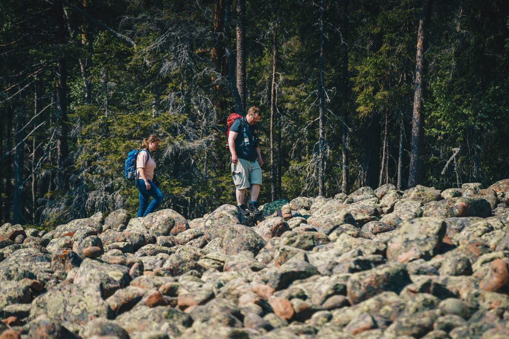 Picture of two people walking on a cobble field.